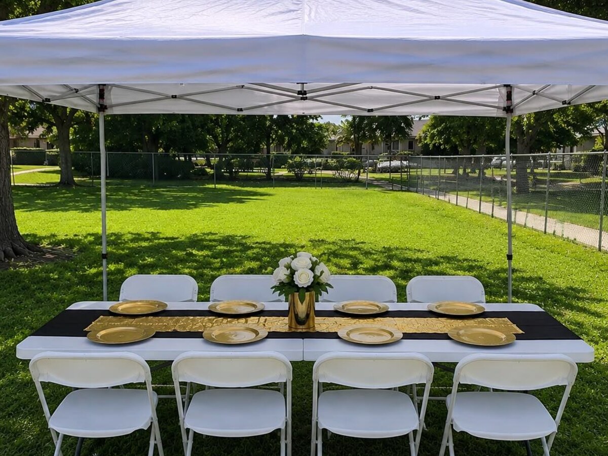 Carpa 10x10 blanca con mesa, mantel negro y sillas blancas en jardín